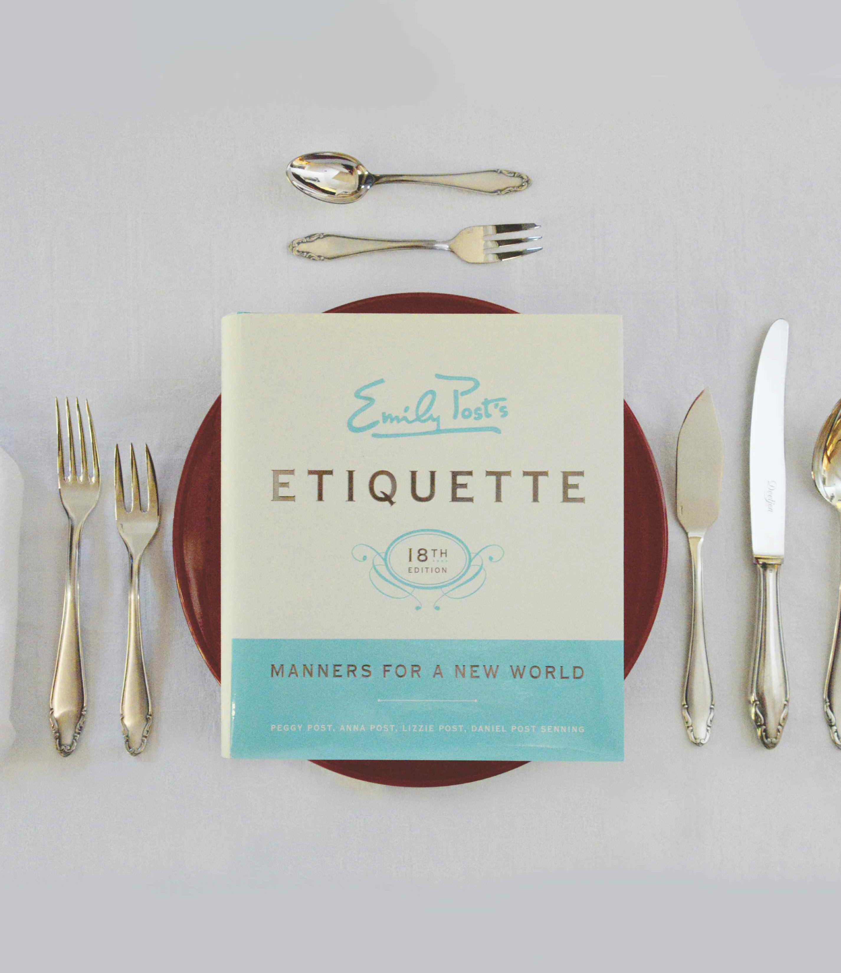 Etiquette sitting on a plate and silverware arrangement