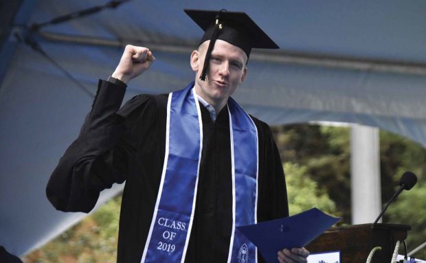 A graduating senior celebrating after receiving his diploma