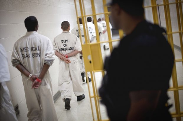 A guard looks on as prisoners move through the state prison in Jackson, Ga.