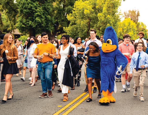 Recent graduates make the traditional exit through the College Gates during the May 2022 delayed Commencement celebrations for the pandemic Classes of 2020 and 2021.