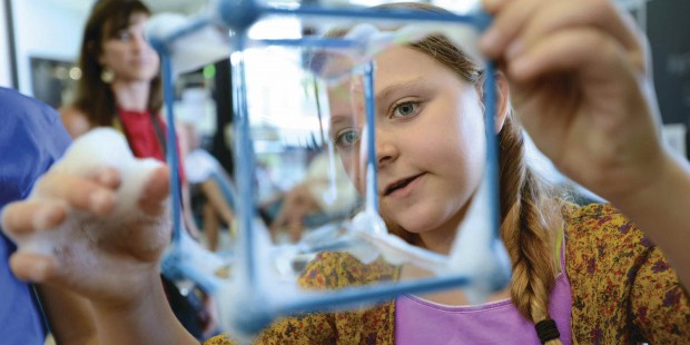 A visitor looking at a cube-type-structure with soap bubbles