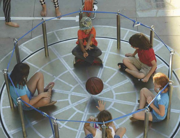 Children sitting in a circle and passing around a ball