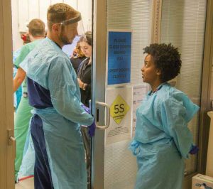 Toles and chief resident Taylor Stayton gown up for a trauma case. 