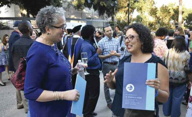 During the reception following her installation, Starr speaks with Assembly member Cristina Garcia ’99.