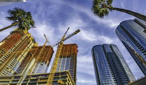 Cranes above a Los Angeles skyline.