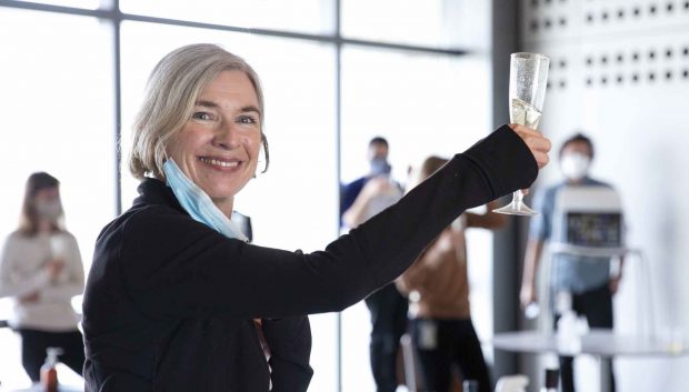 Doudna raises a glass of champagne as she celebrates with her research team.