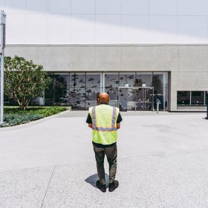 Wearing a safety vest, Professor Sandeep Murkherjee looks at his work through the entrance of the YouTube Theater at SoFi Stadium during the construction process.