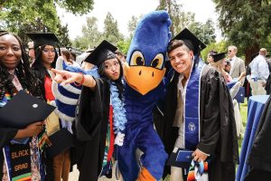 Shari Evangelista and Hermo Quispe mug with Cecil during the 2022 Commencement celebration