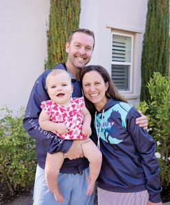 Lucy, Zach and Geri Landman wearing branded apparel