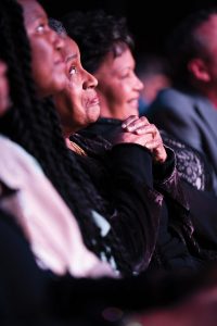 Myrlie Evers-Williams ’68, hands clasped, listens during the 90th birthday gala honoring her legacy in March in Bridges Auditorium.