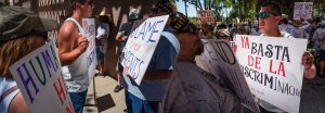 This 2022 montage depicts a stare down at the 2018 Families Belong Together rally at the Arizona State Capitol in Phoenix.