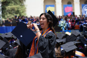 2025 Commencement graduate giving heart sign