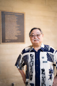 Hongo standing in front of plaque of his poem