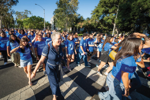 G. Gabrielle Starr and students walk through the gates of Pomona College