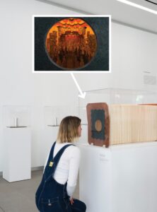 A visitor at the Benton Museum of Art at Pomona College kneels to view a 19th-century Religious Festival Viewing Theatre.