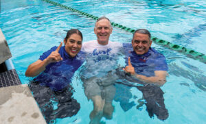 A woman and two men in a swimming pool